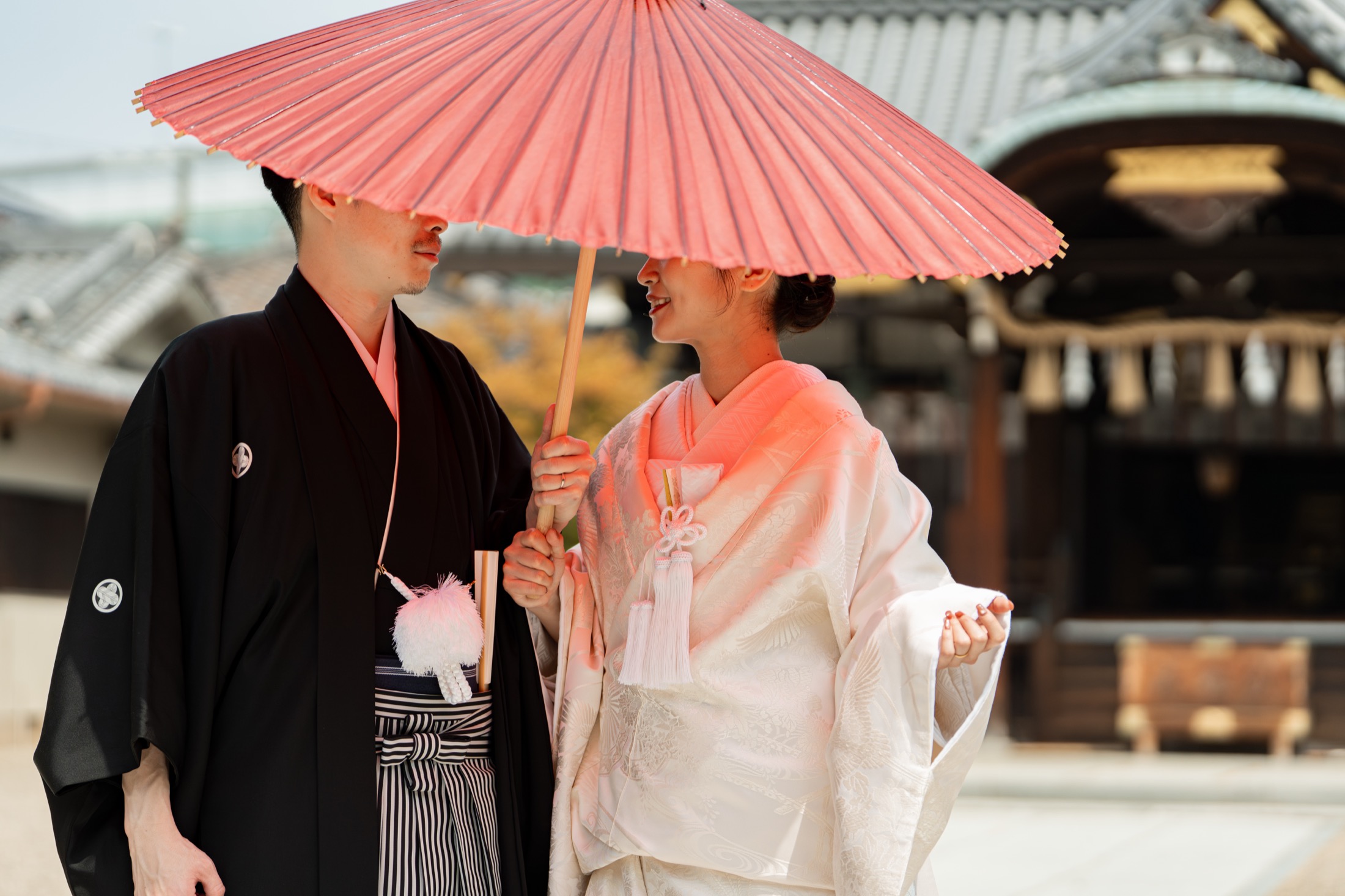和傘を差した新郎新婦